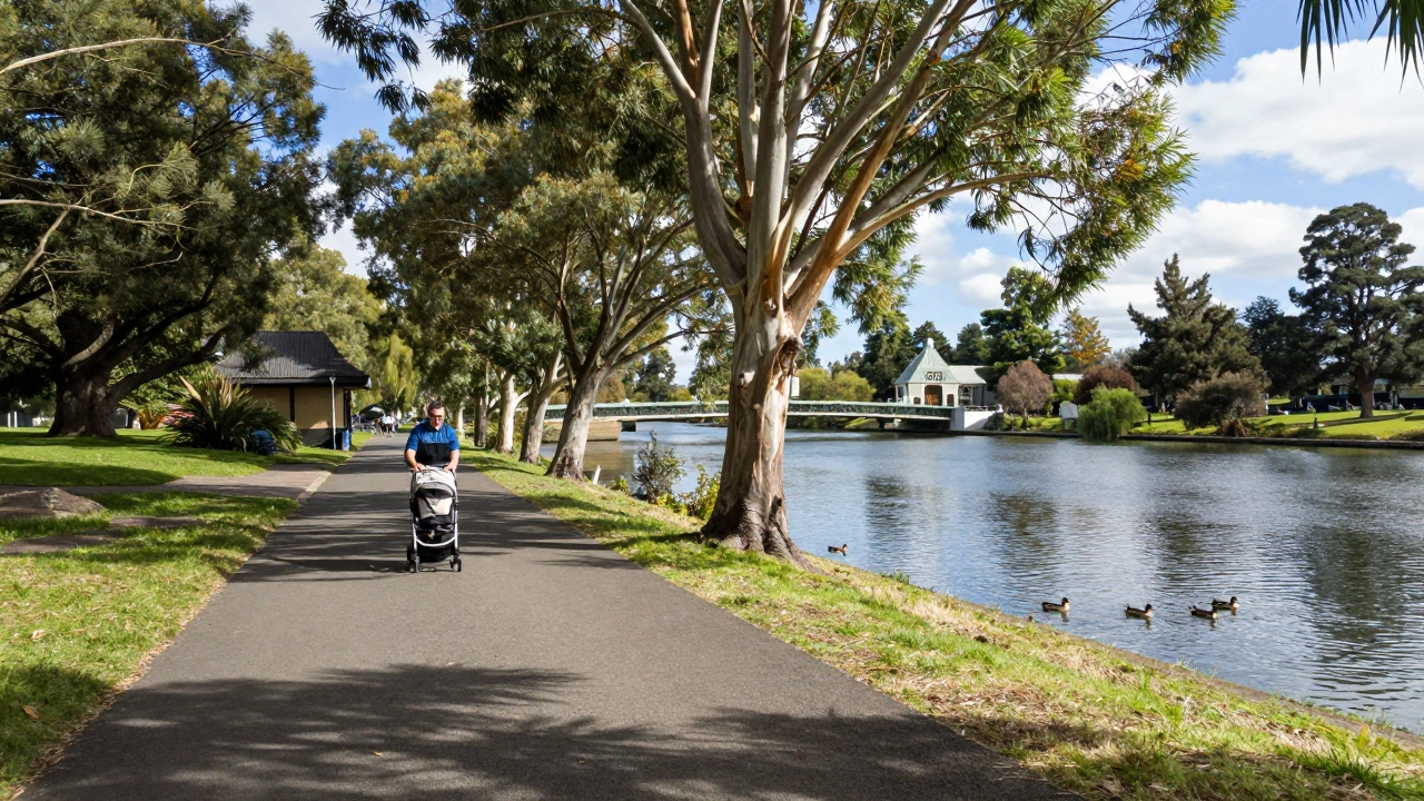 Parent pushing a stroller along the Yarra River Trail with ducks nearby.